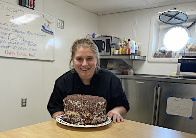 Culinary student Megan Cook with a cake she baked aboard the Training Ship State of Michigan