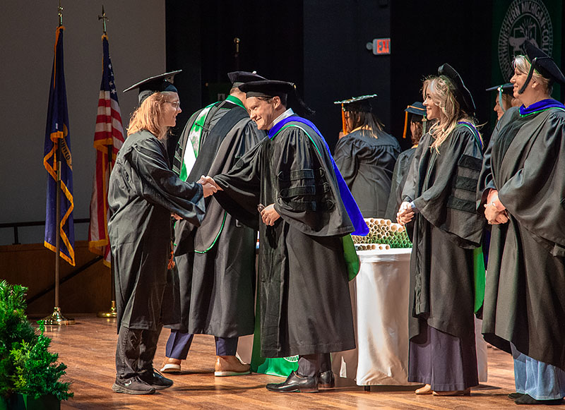 An NMC graduate receives her diploma during the 2026 Commencement ceremony